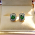 Detail of silver stud earrings with oval green sapphire and sparkling white crystals - Green Stud Earrings