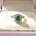 Close-up of luxury emerald-cut green gemstone ring with white diamond pavé setting - Green Ring