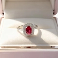 Macro shot of oval red ruby ring with double halo diamond setting in a jewelry box - Red Ring
