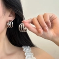 Close-up of three-layered silver titanium steel hoop earrings with polished finish on model - 25mm / Simple C-Shaped Hoop (PJER253) / Steel
