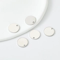 Dettaglio di cinque ciondoli tondi in metallo argento lucido per la creazione di gioielli - 10mm / Bianco K