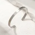 Polished stainless steel minimalist cuff bangle on a natural stone textured background - Silver Open Bangle