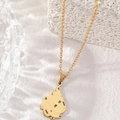 Elegant gold hollow flame pendant necklace displayed on a textured white stone surface - Gold Allah Symbol Necklace (Teardrop Cutout)