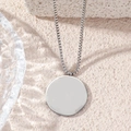 Detailopname van een zilveren ronde hanger met boxketting op een stenen ondergrond - Zilveren Ronde Hanger Ketting