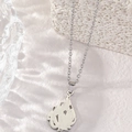 Polished silver stainless steel necklace with flame cutout pendant on stone display - Silver Allah Symbol Necklace (Teardrop Cutout)