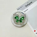 Gros plan du support de téléphone papillon avec gemmes vertes et strass brillants - Vert