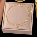 Detail einer goldfarbenen zweilagigen Edelstahl-Fußkette mit einem Herzanhänger - Perlen-Herz-Doppelkette (B5041)