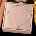 Silberne Schlangenkette Fußkettchen mit Herzanhänger und Metallperlen auf Schmuckkästchen - Stahlfarbener Spitzer Herzstil (B5043)