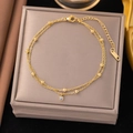 Zweilagige goldene Titanstahl-Fußkette mit kleinen runden Perlen und einem Zirkonia-Anhänger - Zweilagiger Zirkonia-Akzent-Stil (B5034)