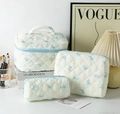 Three-piece quilted cotton makeup bag set with blue ribbon pattern and zip closure - White Background Blue Bow