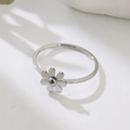 Macro top view of a polished silver daisy ring on a white minimalist background - US 4 / Steel