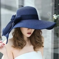 Navy blue wide brim straw sun hat featuring a large ribbon bow accent for beach travel - One Size / Navy Blue