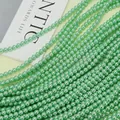 Close-up of light green faux pearls with glossy finish for DIY jewelry making - Fruit Green (no. 23) / Approximately 200 Pieces Per Strip 4mm In Size.