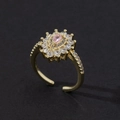 Macro view of adjustable gold ring featuring a pink pear-cut stone with zircon halo - Style 23