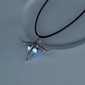 Detailed view of silver ox skull necklace featuring luminous glowing blue eyes at night - Sky Blue Bull Head (NY935)
