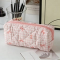 Pink and white checkered quilted cosmetic bag with red bow print and zipper closure - Small / Pink Grid with Bow