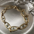 Bracciale a catena dorata con inserti blu quadrati e chiusura regolabile su vassoio - Bracciale Oro
