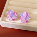 Detail of colorful resin flower beaded ear clips in a beige velvet jewelry tray. - Purple