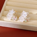 Close-up of white resin flower beaded ear clips with iridescent beads detail - White