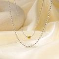 Collar de doble capa en acero de titanio con colgante cilíndrico dorado y cuentas plata - Contraste de Acero y Oro (QYH382)