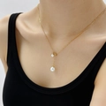 French style Y-shaped gold necklace with double pearls on a model wearing black - Golden Adjustable Pull Pearl Necklace (QYH1323)