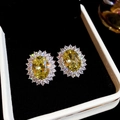 Detailed macro view of yellow oval halo stud earrings in a luxury black jewelry gift box. - Yellow Oval Halo Stud Earrings (20#) / Yellow