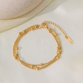 Élégant bracelet triple rangée en acier inoxydable plaqué or 18K sur un tissu de soie blanc - Style Perles à Trois Couches (QYE2129) / Doré