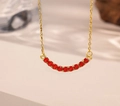 Dettaglio collana dorata con 11 gemme rosse rotonde disposte in un design a sorriso - Zirconia Rossa (Collana d'Oro)