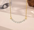 Macro shot of gold smile necklace pendant with 11 round cubic zirconia in claw setting - White Zirconia (Gold Necklace)