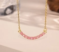 Detailed view of a gold smile necklace featuring eleven radiant round pink gemstones - Pink Zirconia (Gold Necklace)