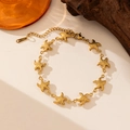 Detalle macro profesional de pulsera en acero inoxidable dorado con dijes de estrella - Pulsera de Cadena de Estrellas de Mar Enlazadas (E2190) / Dorado