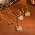 Detailopname van gouden ketting en oorringen met hartvormige bedeltjes in pavé - Afgerond Hart Halsketting Oorbellen / Goud