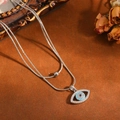 Gedetailleerde macro-opname van zilveren evil eye hanger met lichtblauwe turkoois inleg - Boze Oog Ketting / Zilver