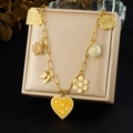 Gold paperclip chain necklace featuring colorful enamel heart and mixed charms on a jewelry box - N4136