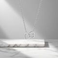 Minimalist silver interlocking double heart titanium steel necklace on marble base - Interlocking Hearts Necklace (QYH6142) / Steel