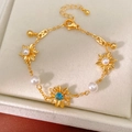 Dettaglio ravvicinato di un lussuoso bracciale a fiori placcato oro con zircone blu e perle - Stile Dorato (HB5325) / Oro