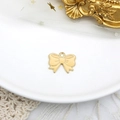 Dettaglio di un ciondolo a fiocco in smalto crema e lega dorata per gioielli fai-da-te. - Fiocco Beige (C-214) / Confezione da 10 / Beige