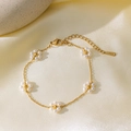 Elegante bracciale in acciaio al titanio dorato con delicati fiori di perle bianche da donna - Bracciale con 5 fiori (Oro)