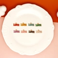 Close-up of colorful enamel LOVE charms for Valentine's Day DIY jewelry and keychains. - Red