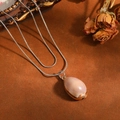 Macro view of a natural shell pendant on a double-layered stainless steel snake chain. - Double Layer Necklace / Steel Light Coffee Conch Style