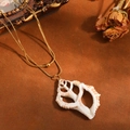 Close-up detail of double-layer gold stainless steel snake chain with hollow seashell pendant. - Double Layer Necklace / Golden Hollow Conch Style