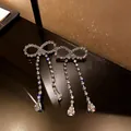 Gros plan sur des boucles d'oreilles nœud vintage avec glands en strass et gouttes - Style 13 Nœud Papillon (Tige en Argent) / Argent