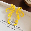 Gros plan de boucles d'oreilles ruban jaune vif avec clous en cristal étincelants - Style 11# Tige en Argent / Style Nœud Jaune
