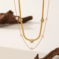 Elegant double-layered gold necklace with pearls, roman numeral pendants and snake chain - Necklace / Gold