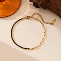 Macro view of gold stainless steel bracelet with black cubic zirconia and long link chain - Gold Spliced Black Zirconia