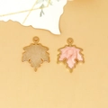Detailed view of a pink enamel maple leaf charm with gold-tone textured metal backing. - Maple Leaf Charm (C-296) / Pearlescent Pink
