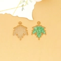 Detailed macro view of green enamel maple leaf charms with gold-plated textured backs - Maple Leaf Charm (C-296) / Pearlescent Green