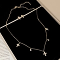 Detailed close-up of a shimmering gold-tone cross necklace and earring jewelry set - Gold