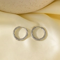 Boucles d'oreilles torsadées en acier argenté sur un fond en soie luxueuse - Torsion de Fleur de Prunier (QYG96) / Acier