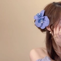 Detail einer eleganten blauen Orchideen-Haarklammer, die romantisch am Haar gestylt ist - Künstlicher Orchideen-Clip / Blau